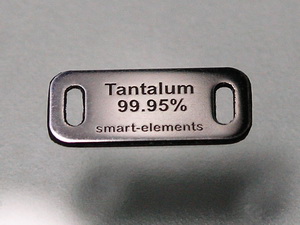 Front of the tantalum tag engraved with the material name and purity